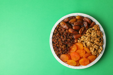 Marble tray with healthy food on green background, top view
