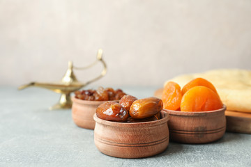 Ramadan Kareem food and Aladdin Lamp on grey table, space for text