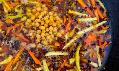 Rice pilaf in a large cast-iron cauldron on fire