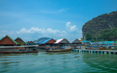 Floating village of sea gypsies near the rocks in the sea. Archipelago in the Andaman Sea. Thailand.