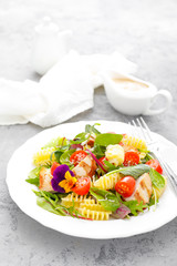 Pasta salad with grilled chicken meat, vegetables and cheese
