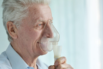 Close up portrait of senior man with inhaler