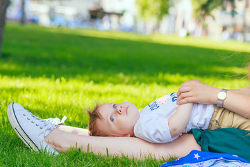 portrait of a young boy blond with blue eyes who smiles in the summer in sunny weather