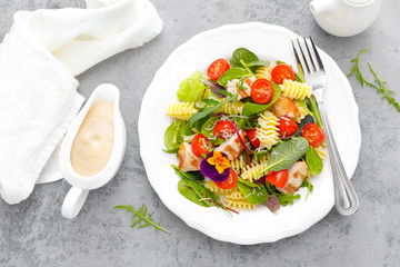 Pasta salad with grilled chicken meat, vegetables and cheese