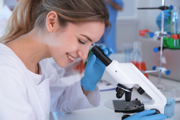 Medical student working with microscope in modern scientific laboratory