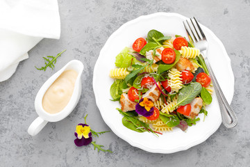 Pasta salad with grilled chicken meat, vegetables and cheese