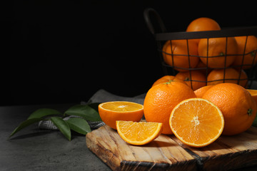 Wooden board with ripe oranges on table. Space for text