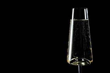 Glass of champagne on black background, space for text