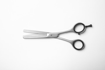 New thinning scissors on white background, top view. Professional hairdresser tool