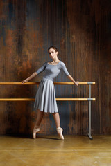 Young beautiful ballerina is posing in studio