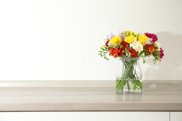 Beautiful spring freesia flowers in vase on table. Space for text