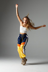 Hip hop dancer moving and jumping in photostudio