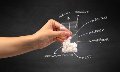 Hand with pills in plastic bag and blackboard wallpaper