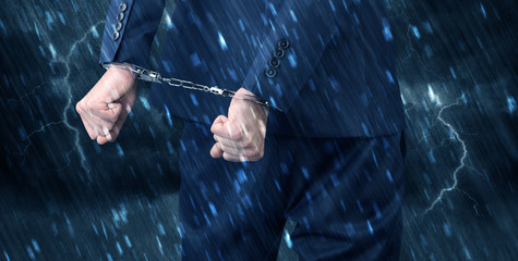 Stormy bad day concept with close handcuffed elegant man
