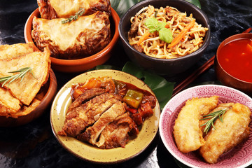 Assorted Chinese food set. Chinese noodles, fried rice, peking duck, dim sum, spring rolls. Famous Chinese cuisine dishes on table. Chinese restaurant