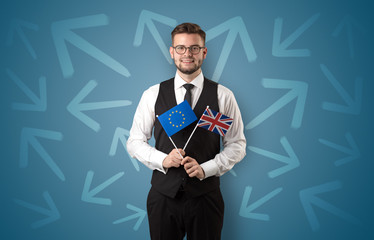 Cheerful elegant boy standing with flag on his hand and chalk drawn arrows around