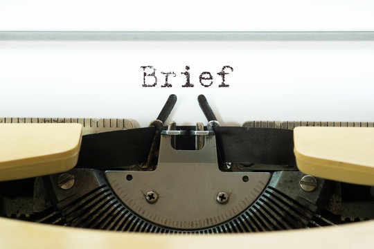 Brief word typed on a yellow vintage typewritter. Business concept.