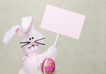 Easter bunny holding a blank poster