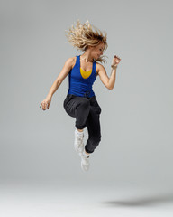 Hip hop dancer moving and jumping in photostudio