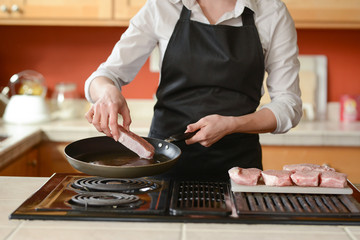 The chef prepares fresh pork steaks in the kitchen, home cooking menu. culinary recipes. restaurant menu.