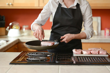 The chef prepares fresh pork steaks in the kitchen, home cooking menu. culinary recipes. restaurant menu. Delicious food