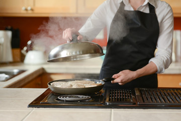 The chef prepares fresh pork steaks in the kitchen, home cooking menu. culinary recipes. restaurant menu. Delicious food, recipes and cooking