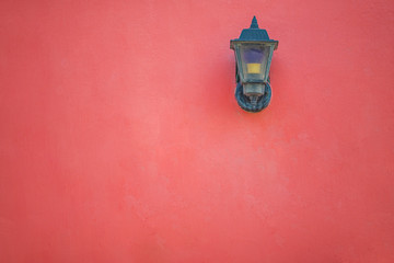 Vintage lamp on red wall.