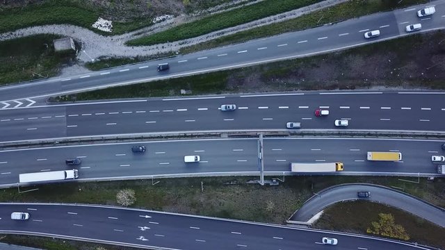 Highway traffic aerial top down view footage from drone with vehicles driving on freeway road with ramp lanes, 4K video of transportation from above