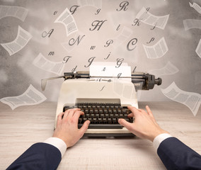 First person perspective hand typewriting with flying documents around
