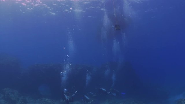 Close Up: Scuba divers Swimming Over Coral Reef With Bubbles Rising in Big Island, Hawaii