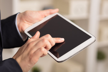 Business woman below chest using tablet in a homey environment
