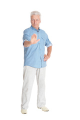 Portrait of senior man showing stop gesture isolated on white background