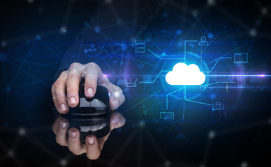 Hand using wireless mouse in a dark environment with cloud technology and online storage concept