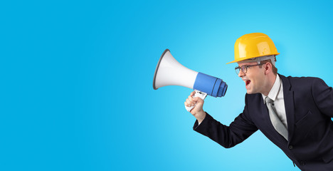 Fototapeta premium Young architect constructor yelling with megaphone and copyspace