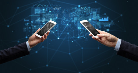 Close up of two hands holding smartphones to sync business data