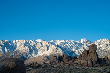 rock formations in front of snowy mountain peaks Sierra Nevada California Alabama Hills