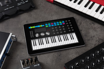 Piano synthesizer app on tablet and musical instrument concept
