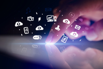 Finger touching tablet with white drawn application icons and dark background
