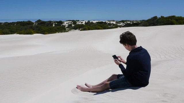 Boy sending message home from remote desert location