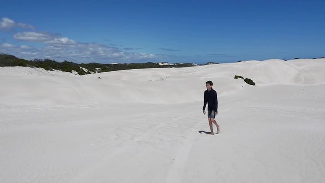 Exhausted teenage boy walking in the heat of the desert