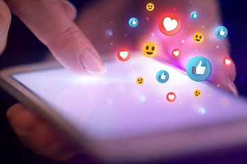 Finger touching phone with social media concept and dark background
