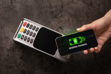 Hand paying with digital currency from smartphone