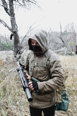 Fototapeta premium Stalker, soldier guy in uniform and with machine gun, portrait in mask close up