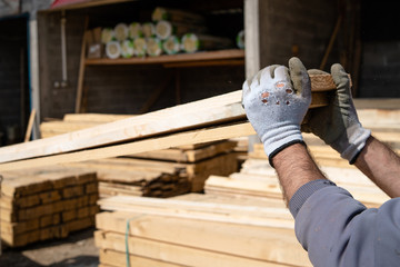 Close up on the worker holding building material planks loading at the warehouse for the construction site