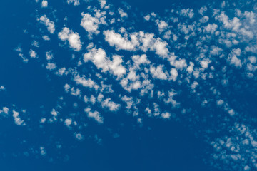 White scattered clouds on the blue sky, view directly below 