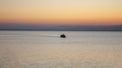 Fototapeta premium Boat with people in Albufera of Valencia at sunset.