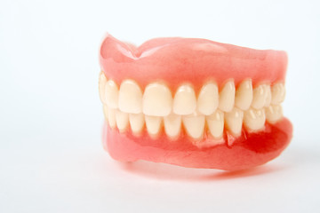 Artificial teeth on a white background with copy space