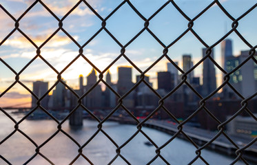 New York City skyline seen through a chainlink fence in Manhattan