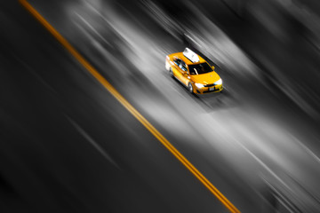Taxi jaune de la ville de New York en mouvement accélérant dans la rue sur un arrière-plan flou