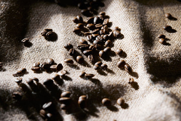 Selective focus of roasted coffee grains on sackcloth texture